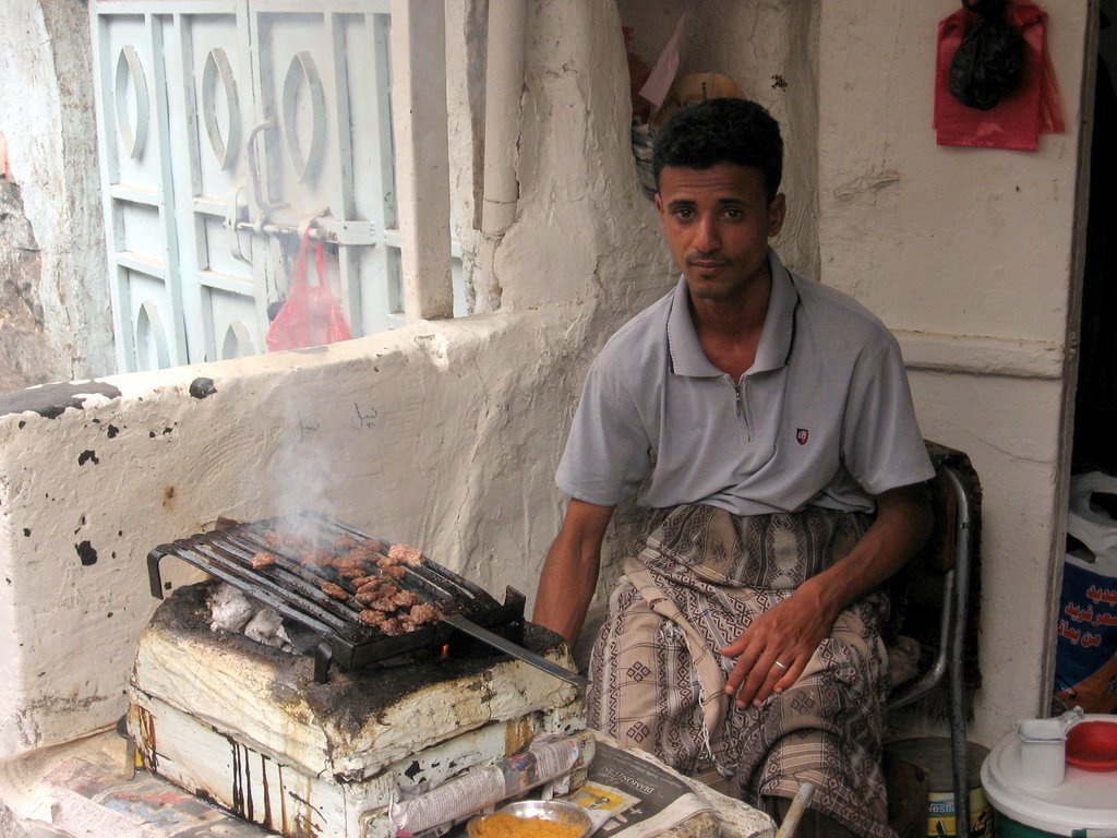 man cooking food with a grill on the stove
