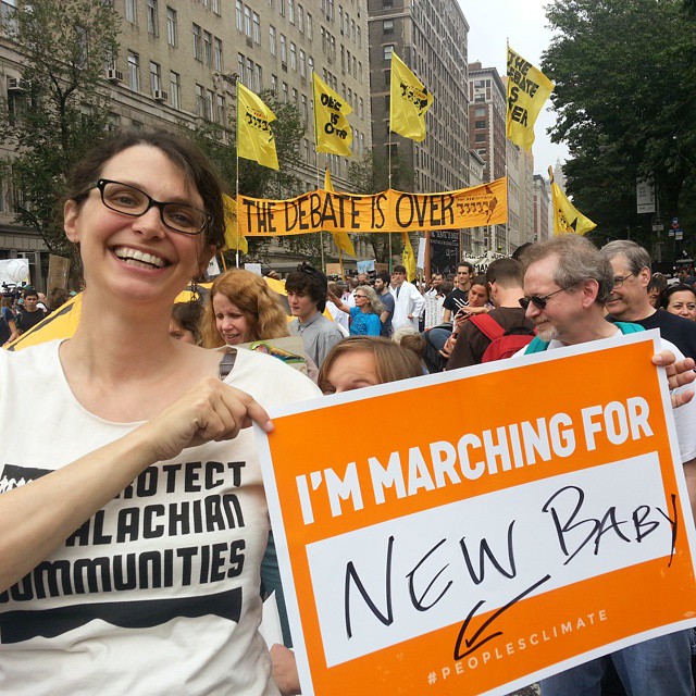 a woman holds a sign for new bar in a crowd