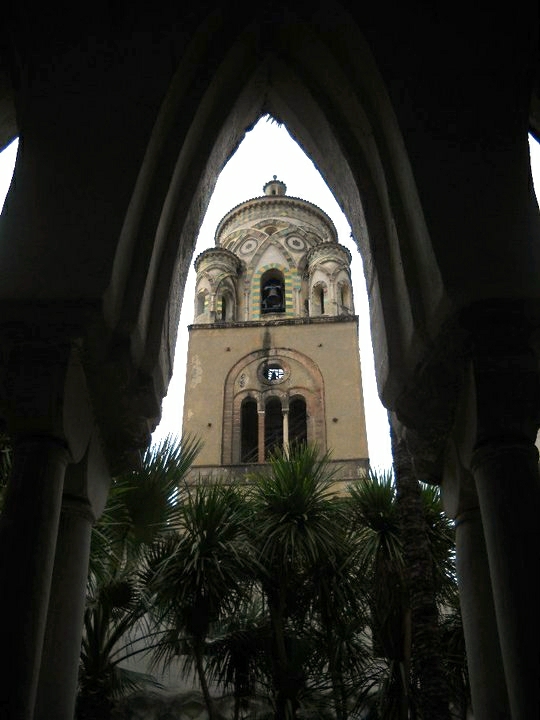 an arch in the center of a church shows a bell tower and dome