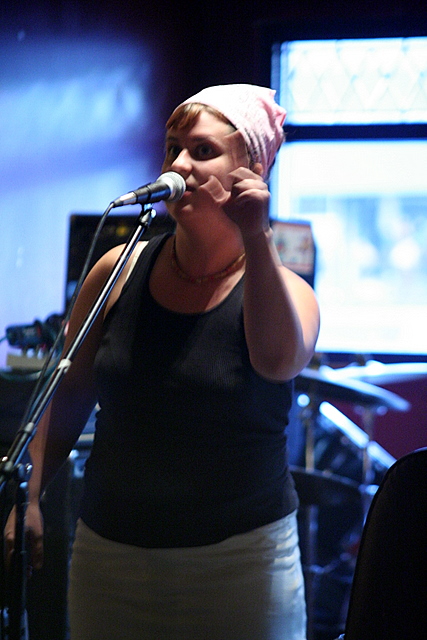 the woman is singing in front of the microphone