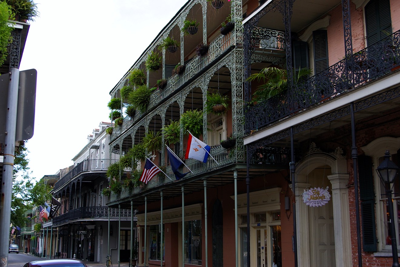 the american flag is hanging from the balcony of a historic building