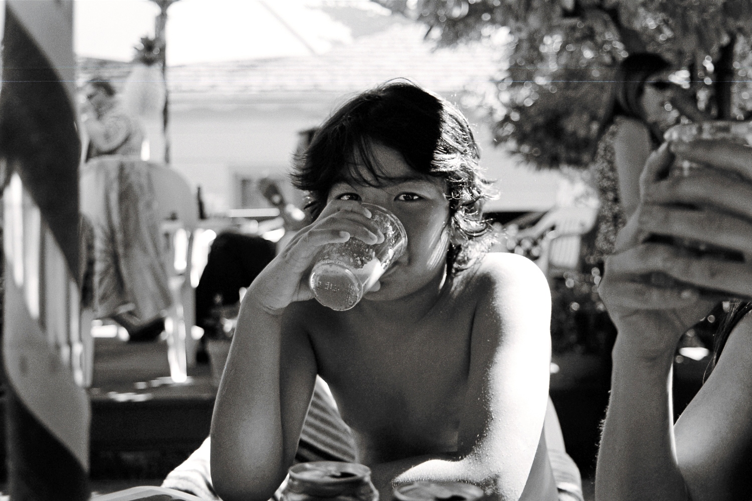 a man drinking from a glass while laying in bed