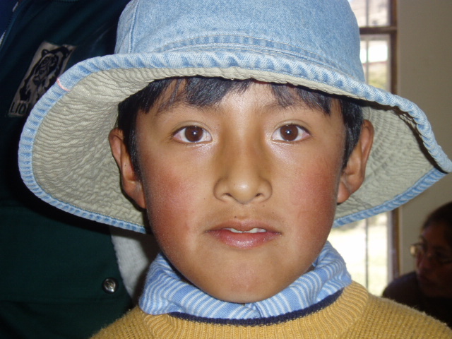 a boy in a yellow shirt and a blue hat