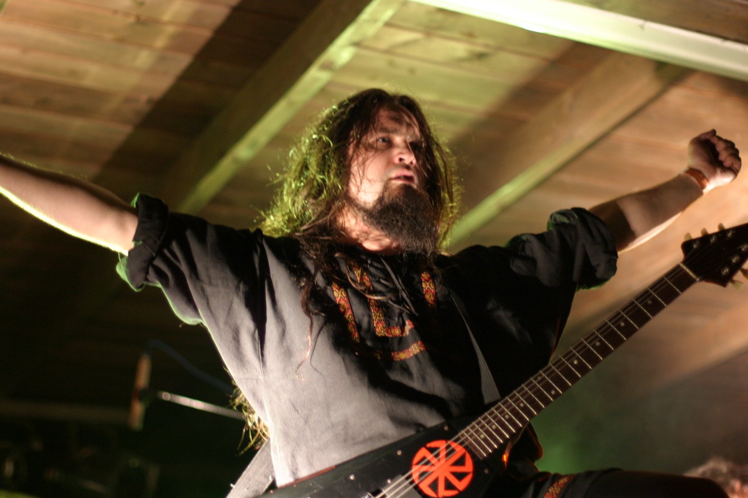 an image of a man that has long hair playing guitar