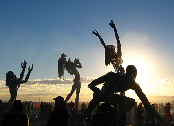 silhouettes of people jumping in the air at an outdoor event