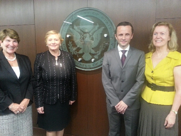 four people posing for a po in front of the us sec logo