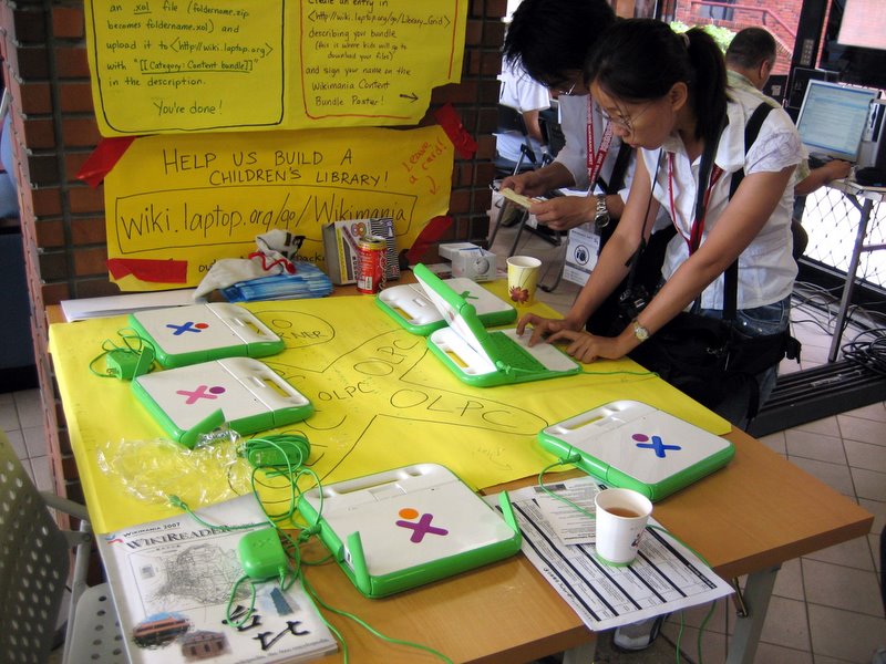 two women are standing at the table making their own lunch box