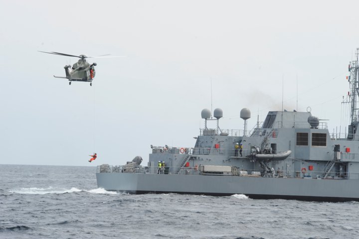 a helicopter flying over a ship on the water
