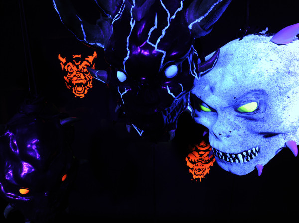 a couple of masks are lit up in purple, green and orange