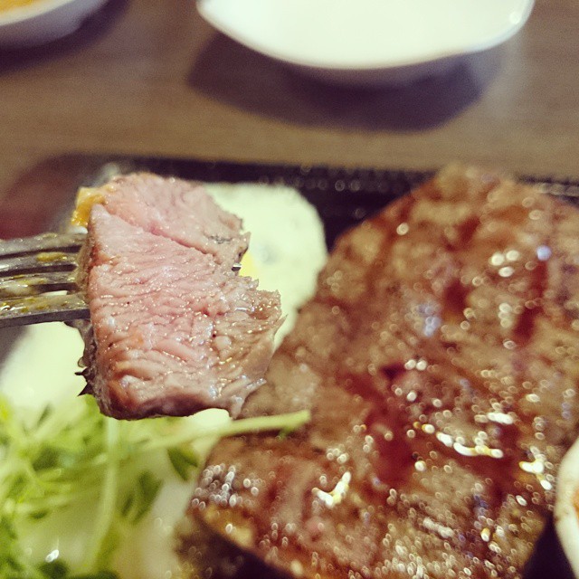 a fork is being used to eat some meat and vegetables