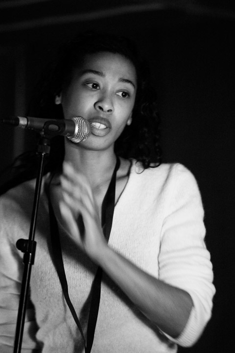 woman in black and white singing into a microphone