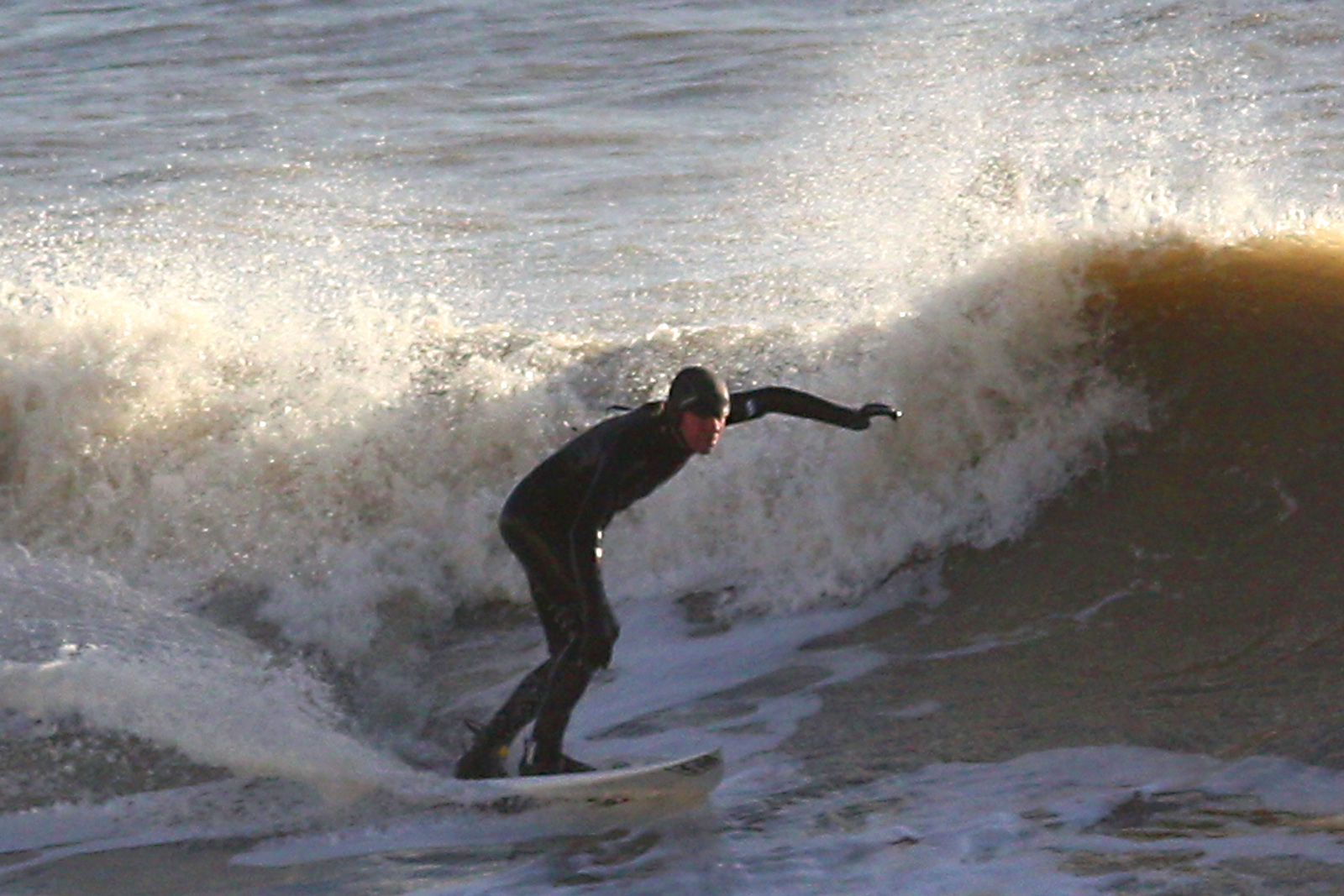 a man surfing on a wave with his arms up