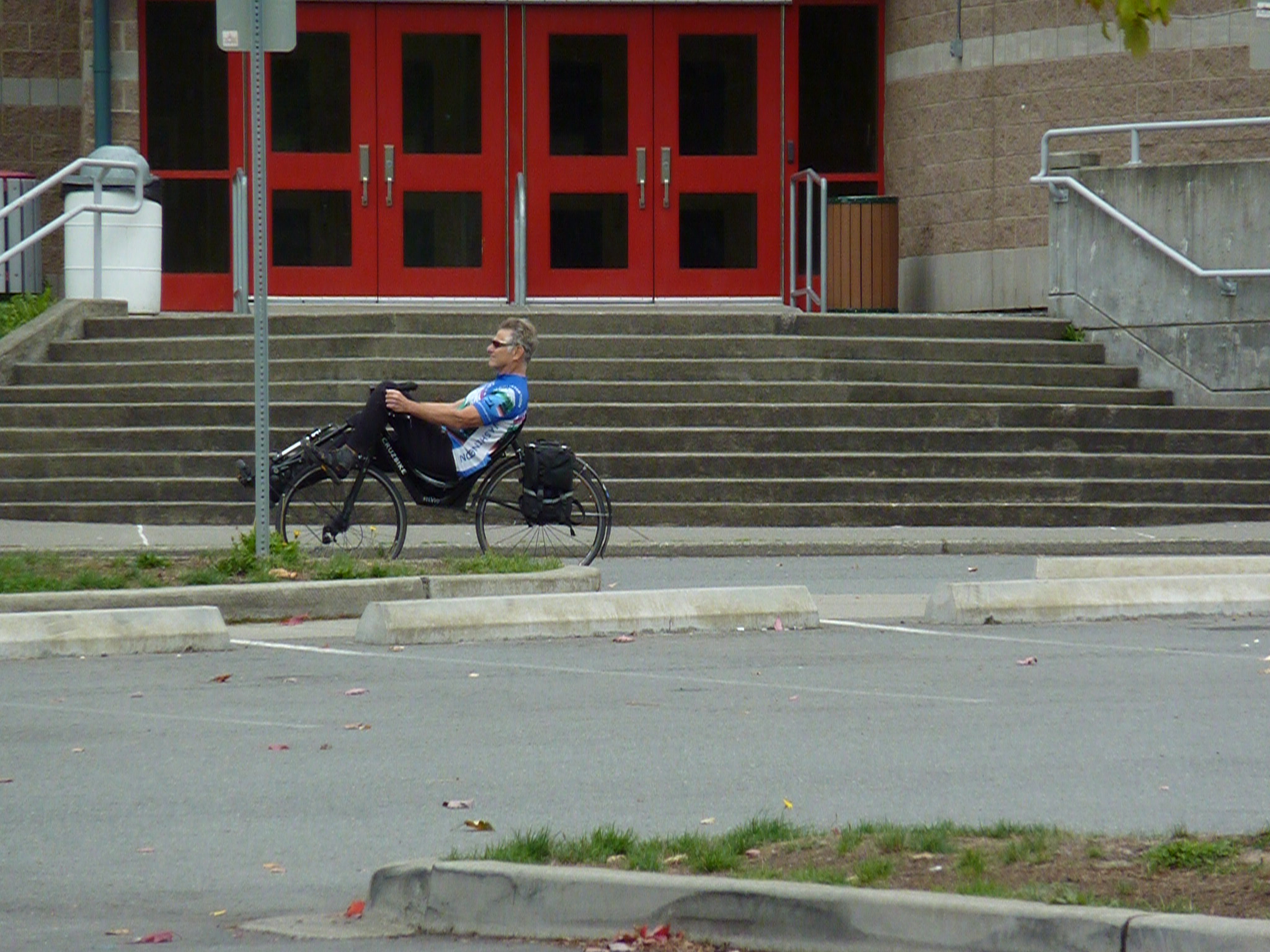 the man is sitting on his bike in front of stairs
