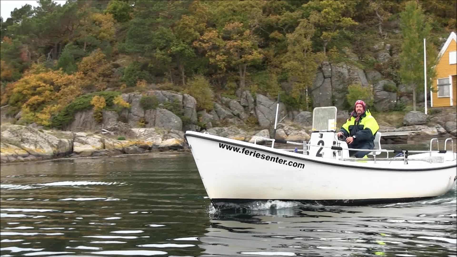 there is a man sitting on the boat on the water