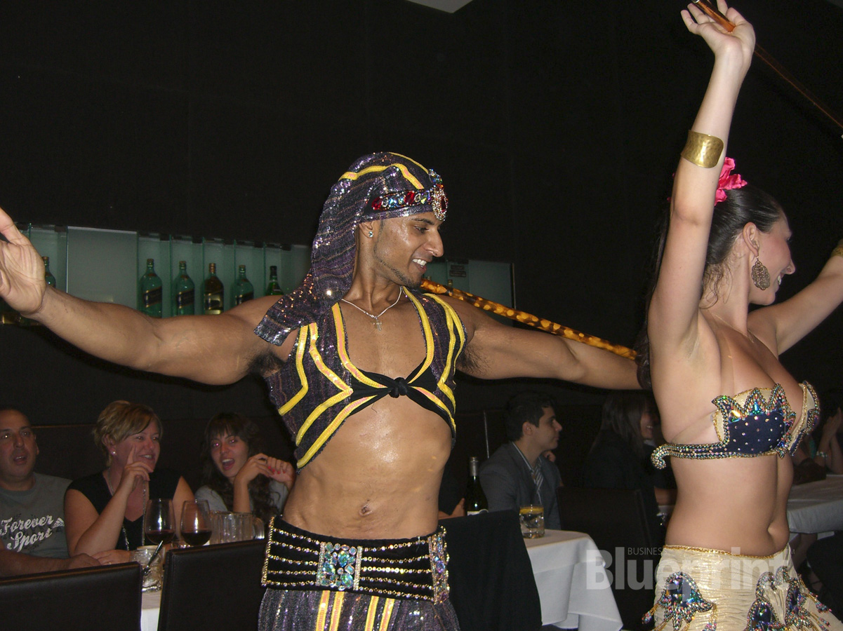 two people dressed in a belly dance pose for a camera