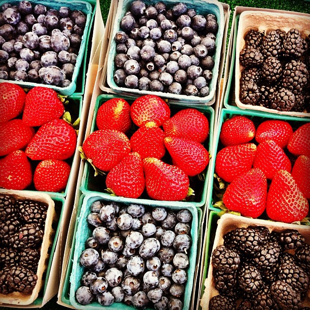 multiple plastic boxes filled with fresh berries and berries