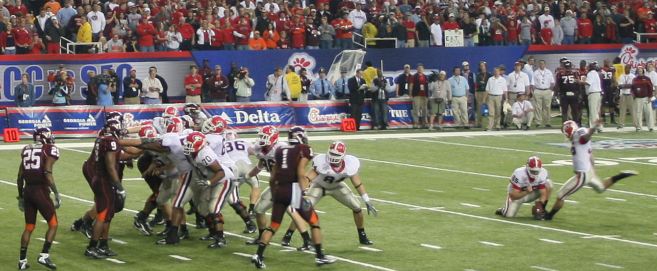 the football team is playing on the field in front of the crowd