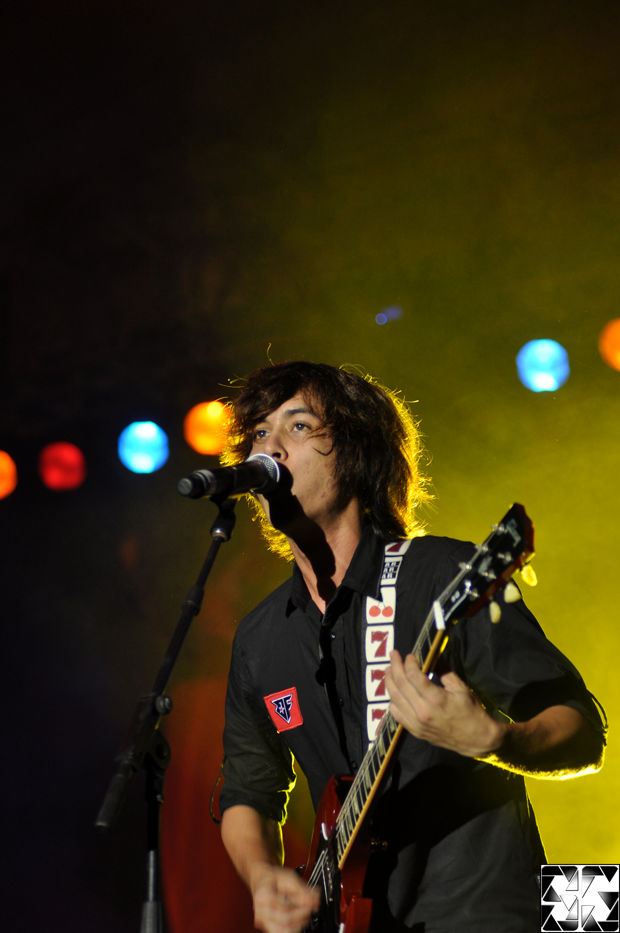 man playing guitar in front of microphone at night