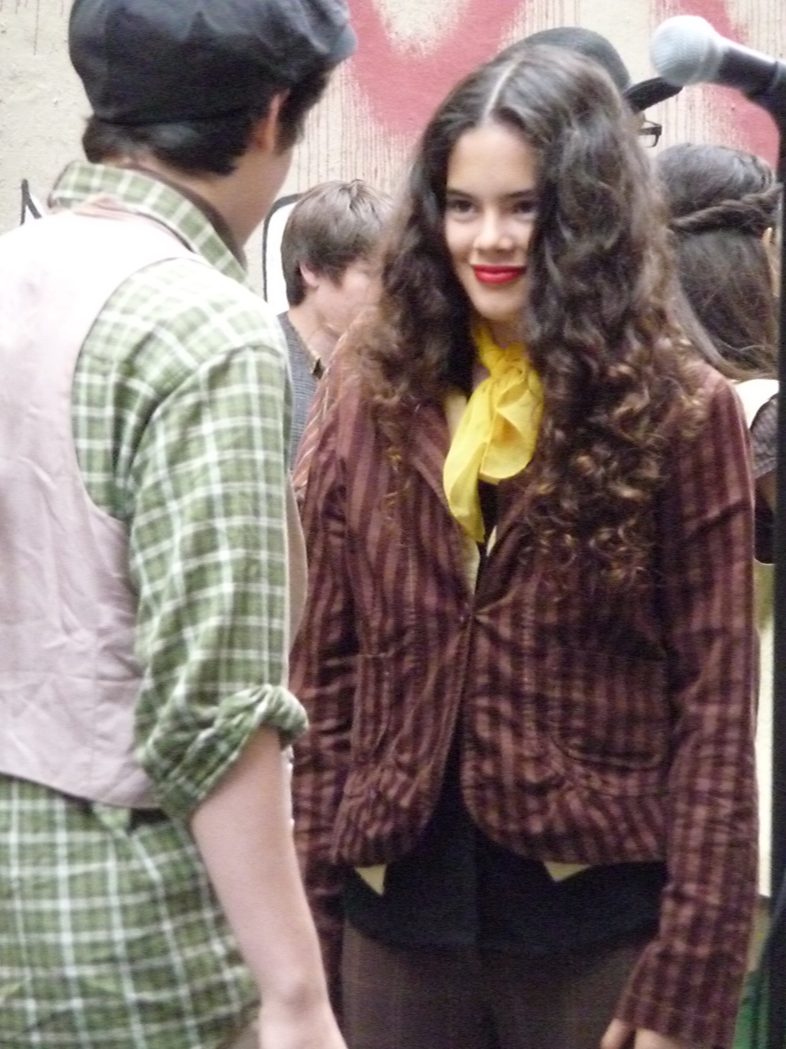 a woman with long hair and black stockings talks with a young man