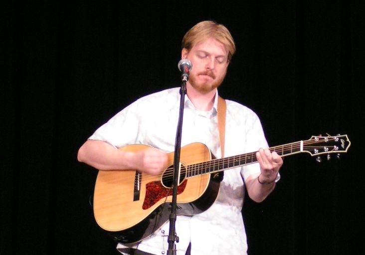 a man is playing the guitar on stage