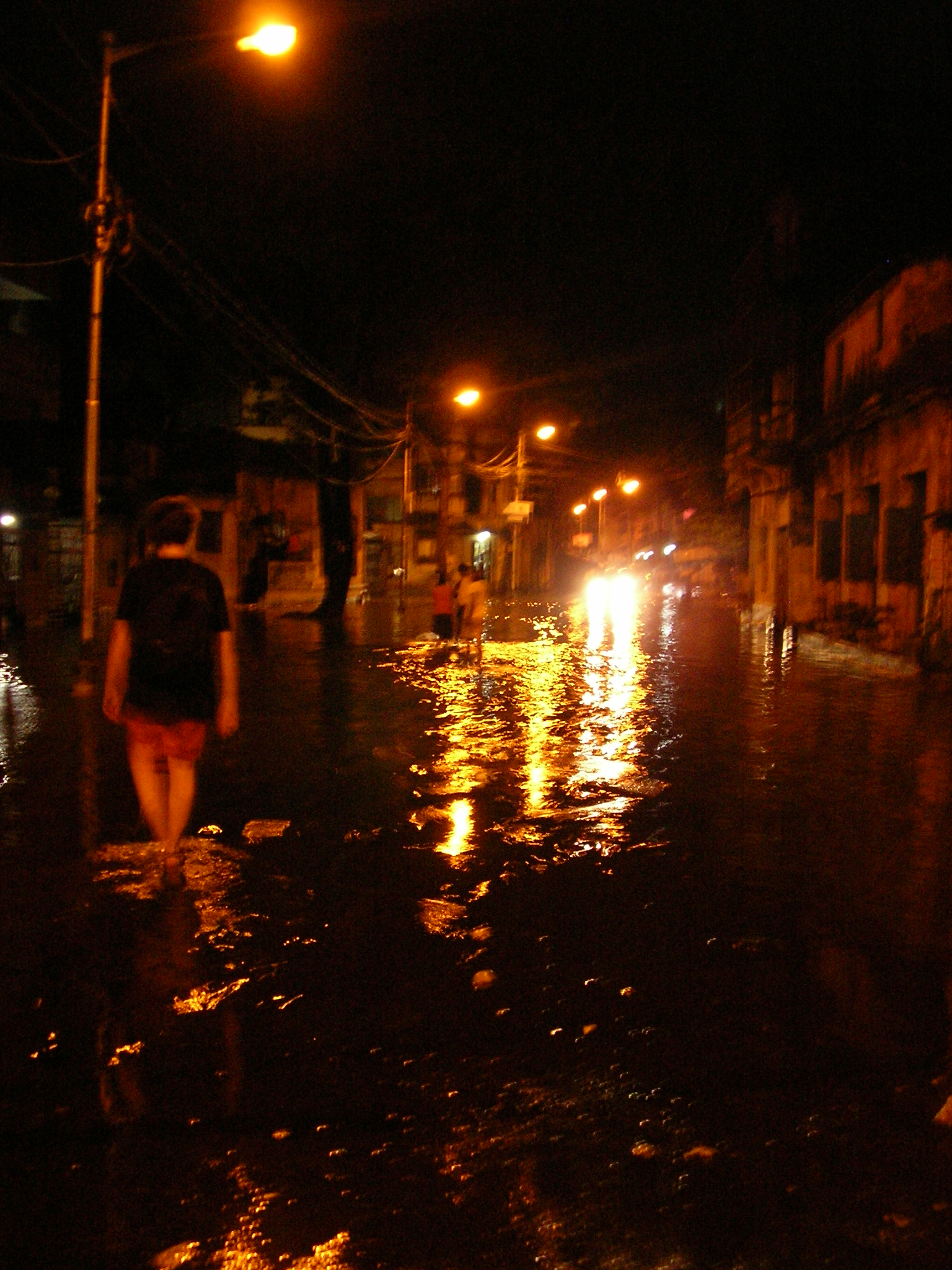 people are walking down the street in the rain