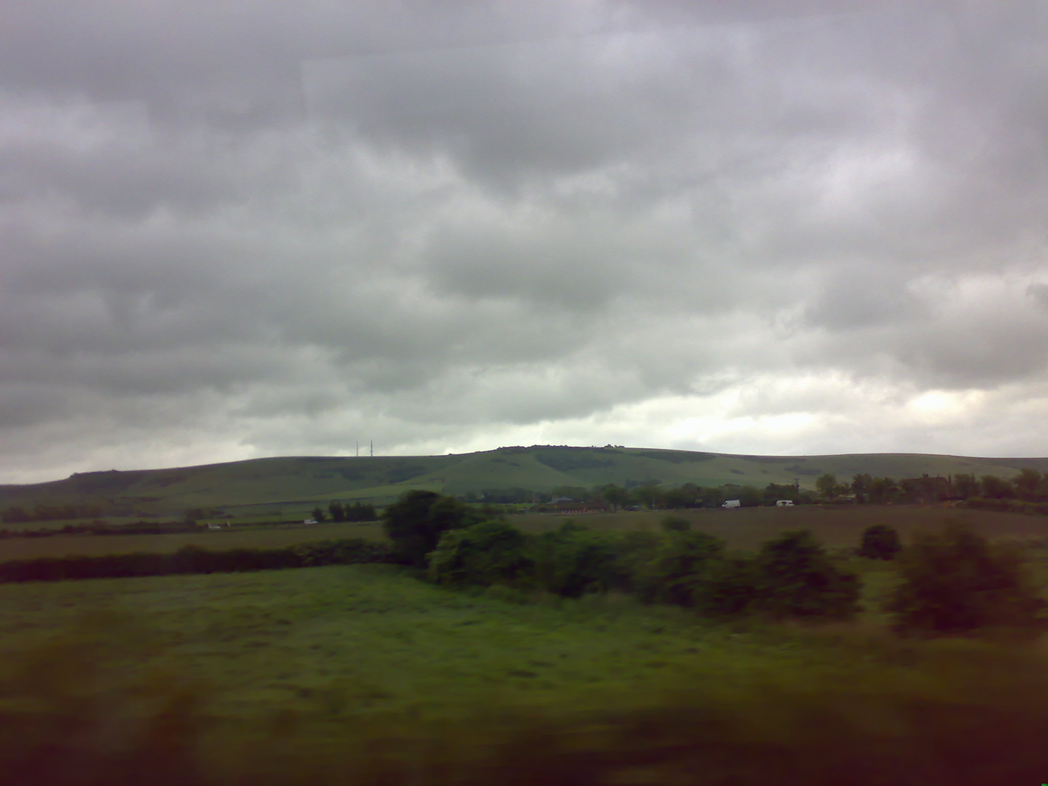 a grassy landscape with green hills in the distance