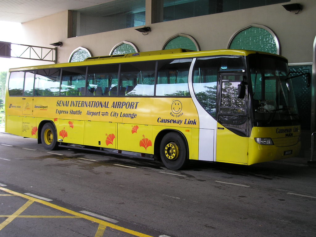 a yellow passenger bus parked outside of a building