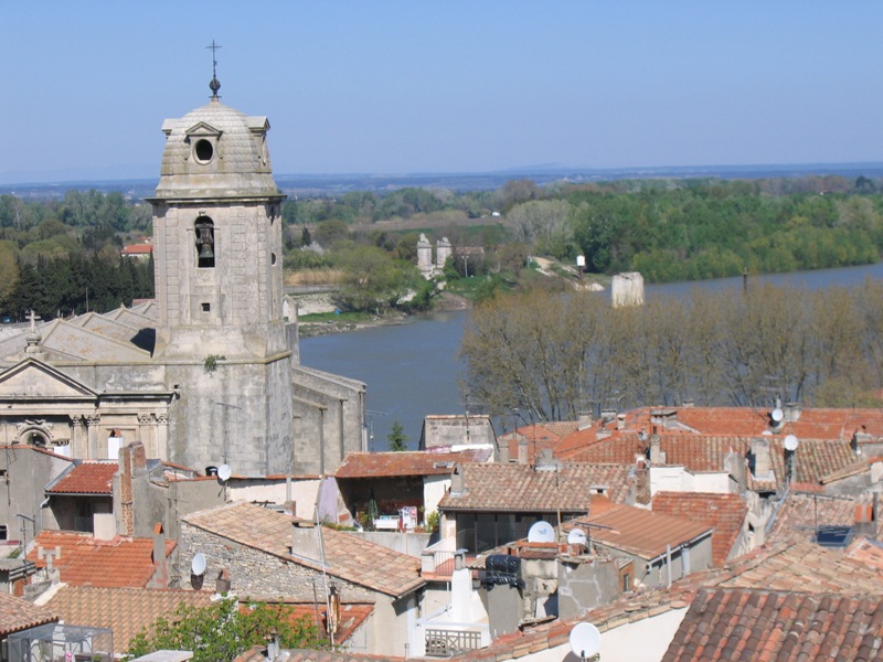 an old church towers over a city with the river flowing between it
