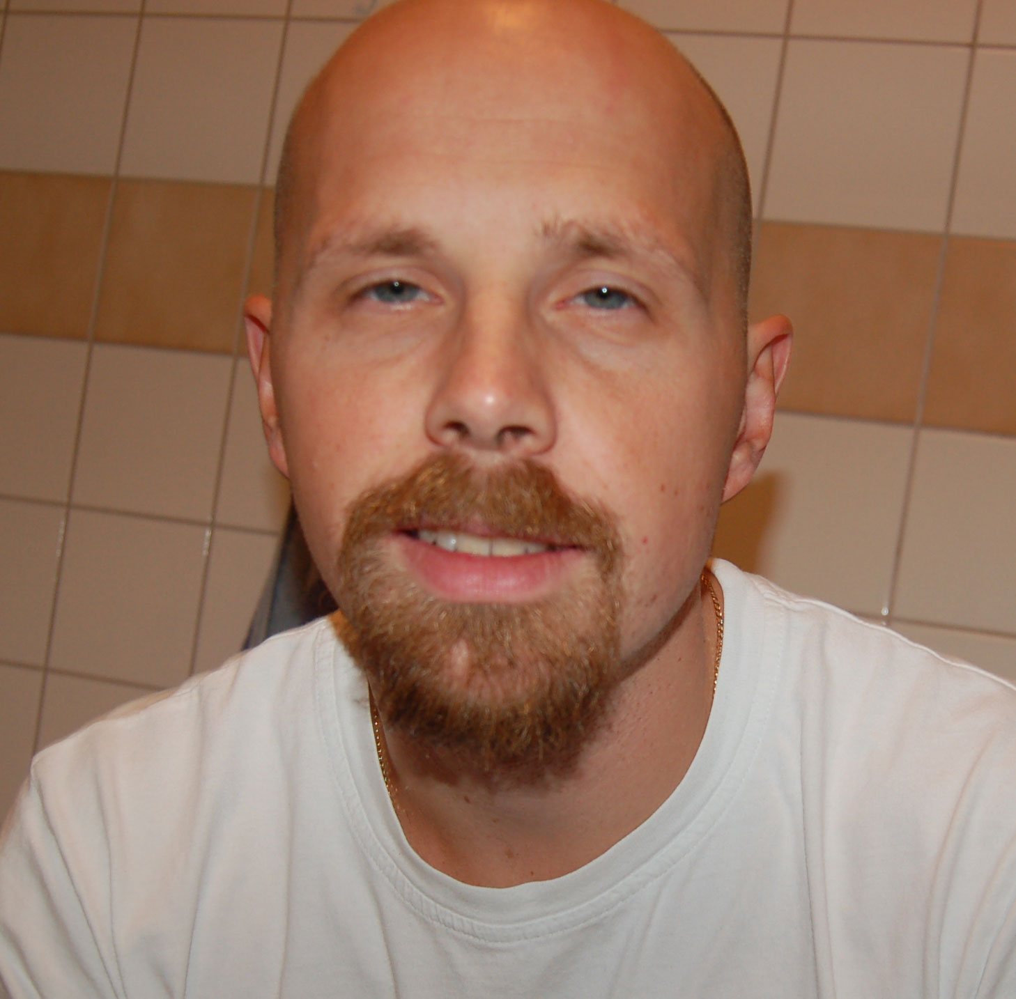 a balding man with an orange beard and a white shirt