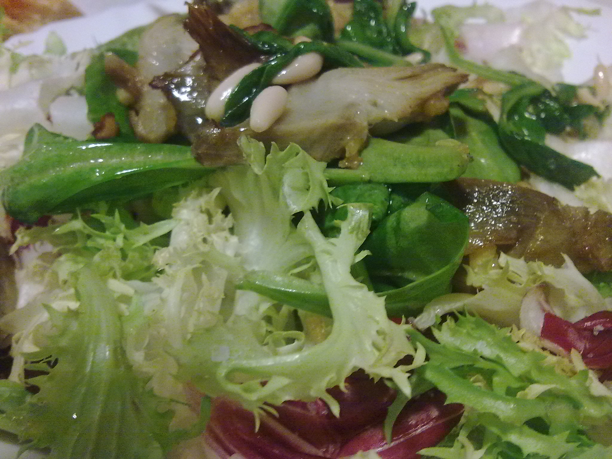 a salad with lettuce, radishes and mushrooms in it