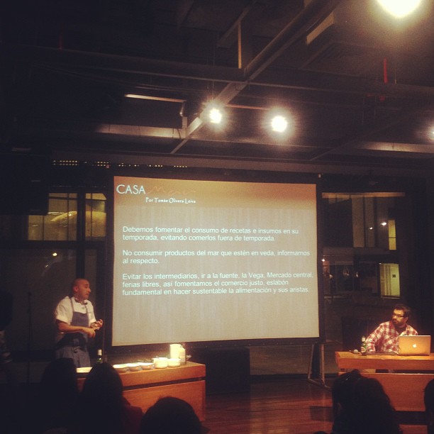 people sitting in front of a big screen with a presentation projected