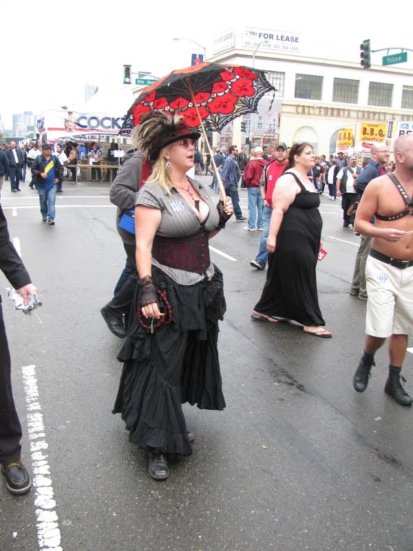 people walk down the street, some dressed in costumes