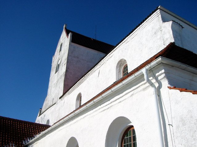 a church with a bell tower next to other buildings