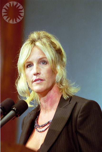a close up of a woman sitting in front of a microphone