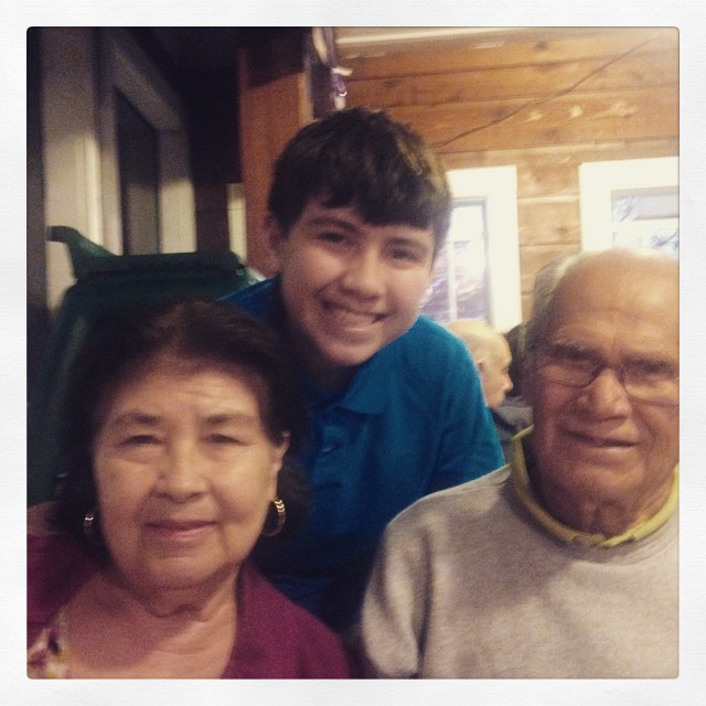 an elderly man sitting in front of two adults