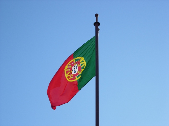 an image of the portugal flag flying on the side of a building