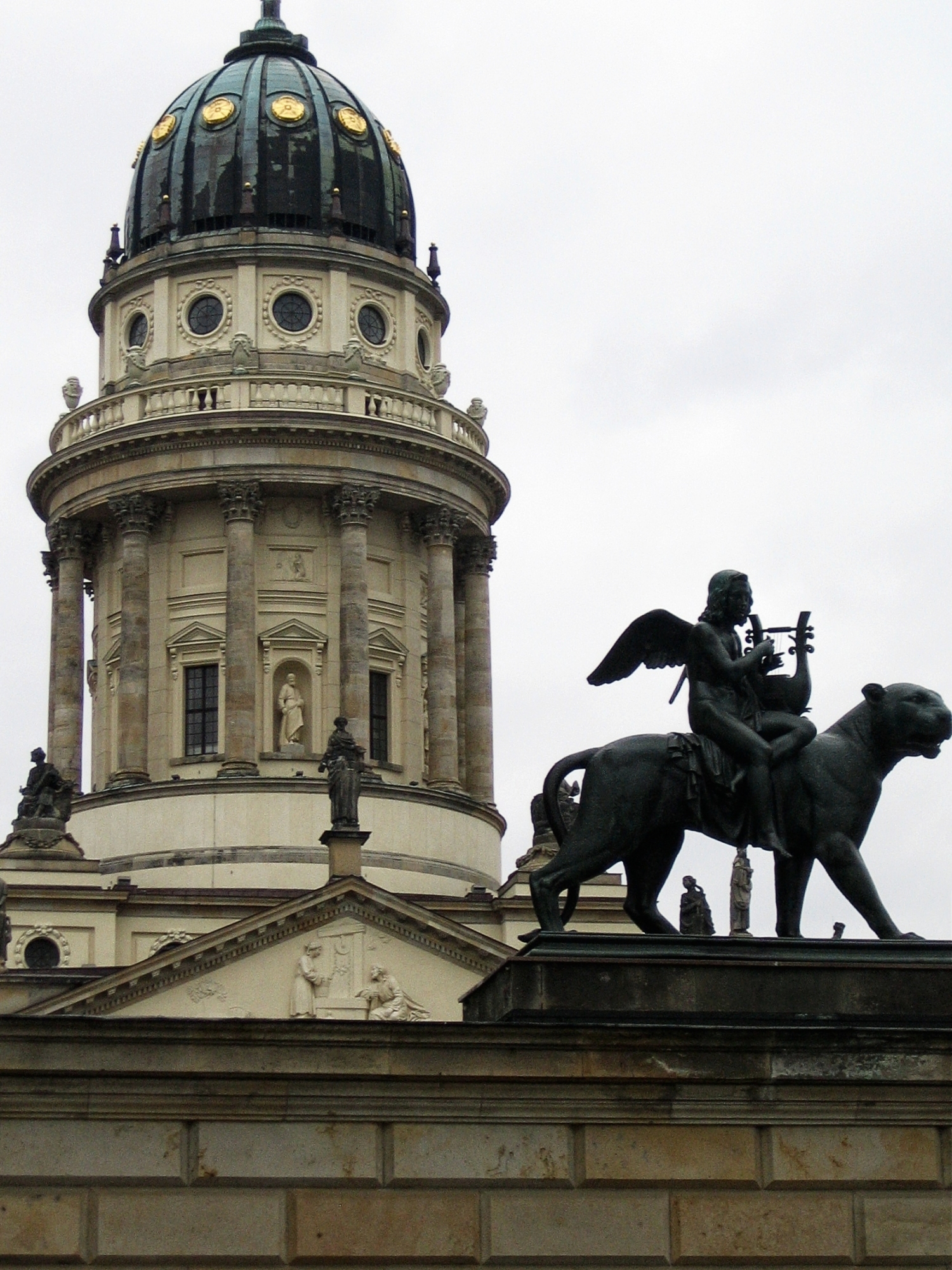 the view of a building with statue and dome in background