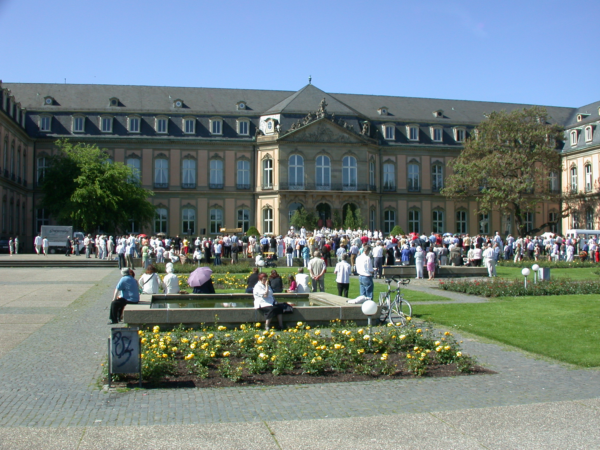 a big group of people are gathered outside a large house