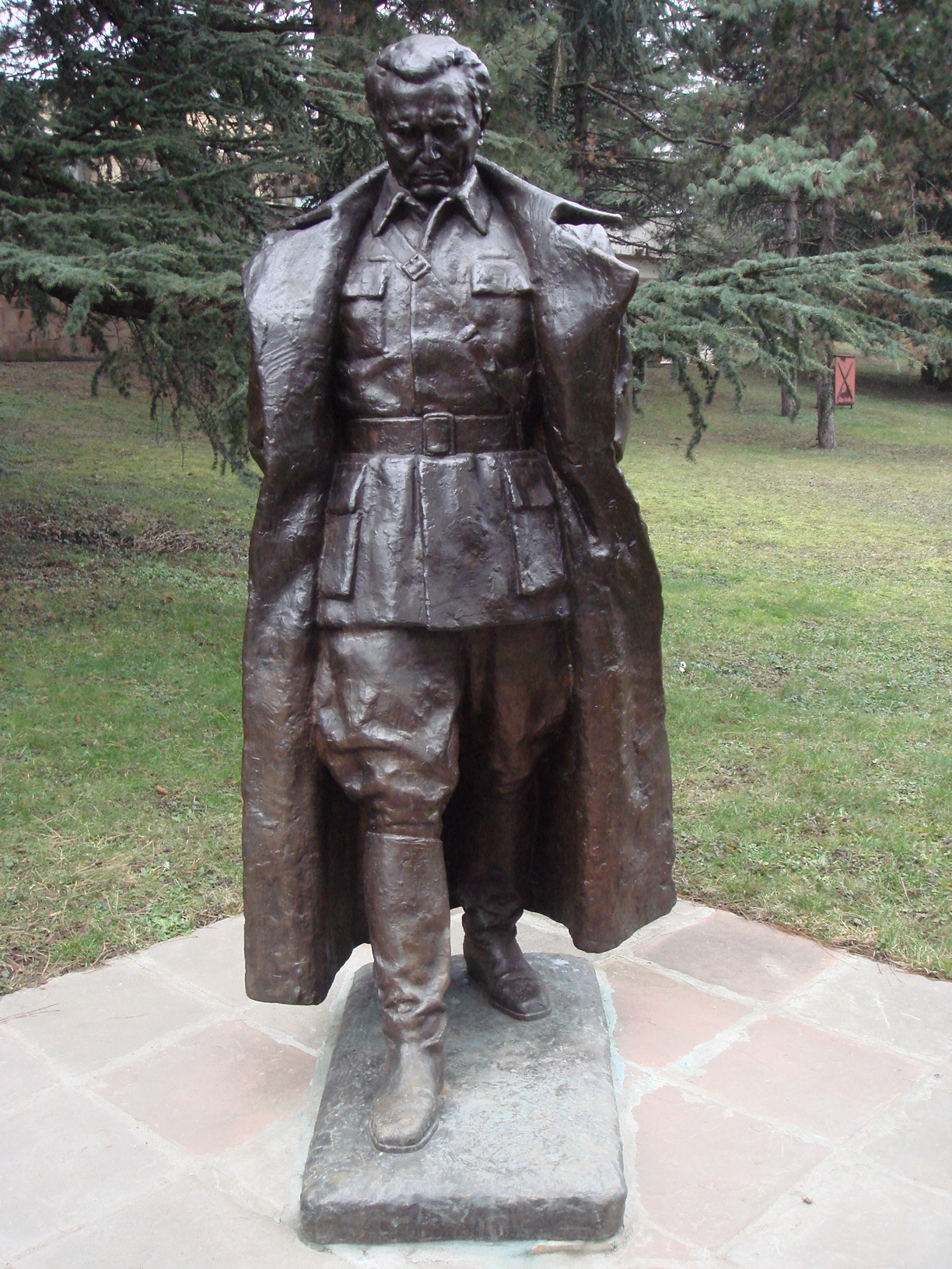 a statue of a man in a suit stands on bricks