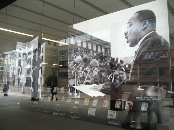 some people walking by a large po with a giant image of martin luther king