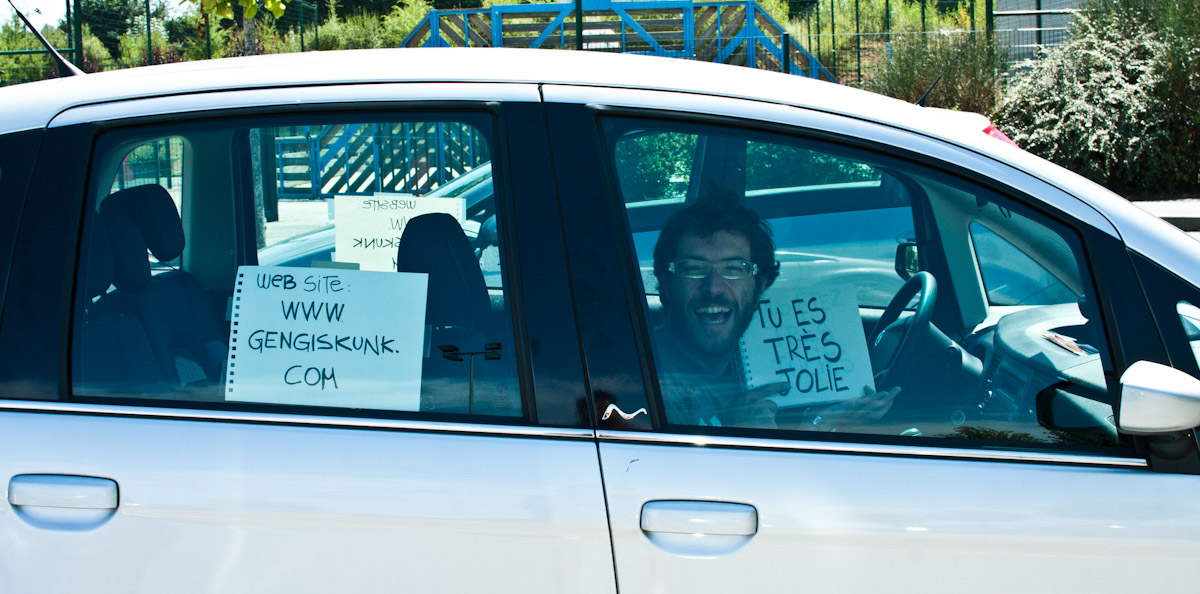 a man sitting in a car and holding up signs