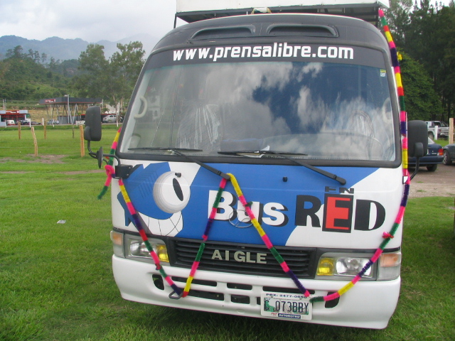 a bus parked in the grass next to trees