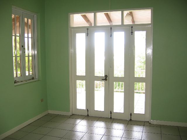 an empty room with three doors and a window