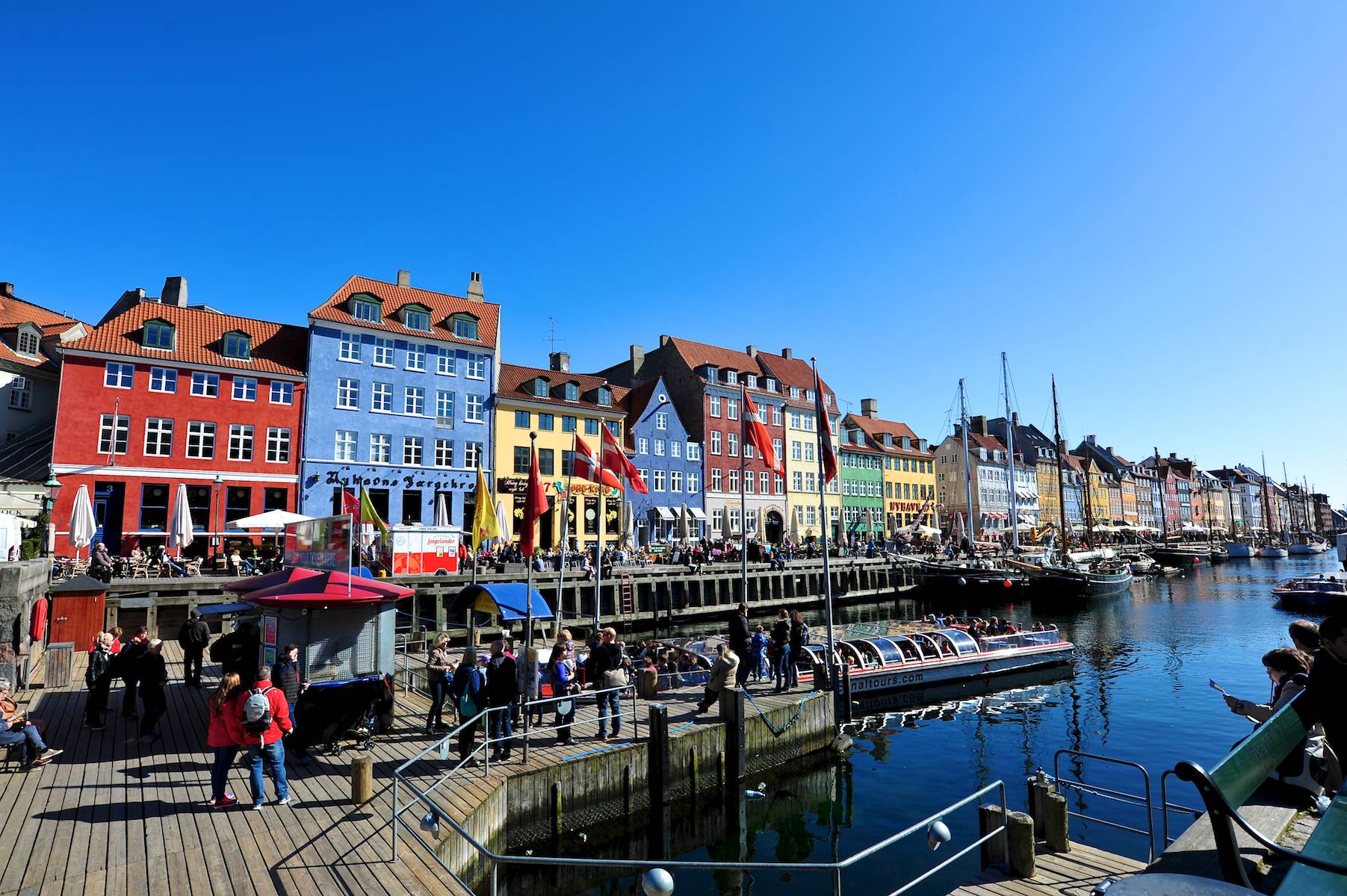 a line of houses near the water with people on a boat