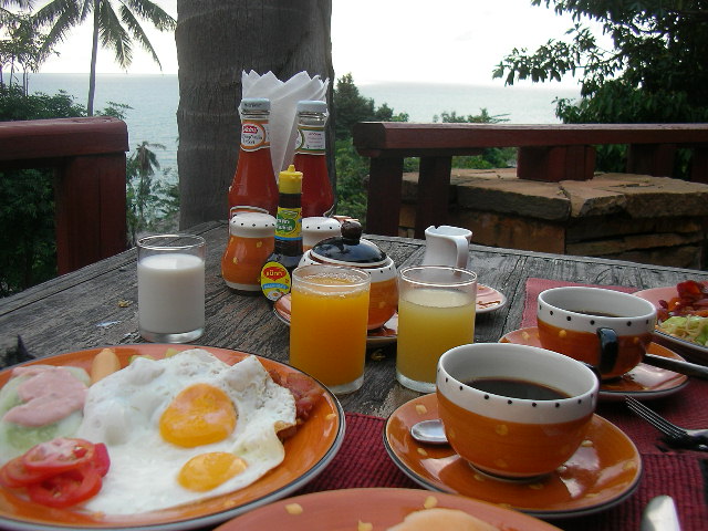 plates with breakfast food on the table next to orange juice and juice
