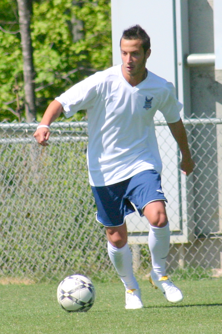 a man in the uniform of a soccer player playing with a soccer ball