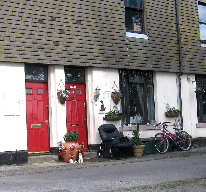 bicycle parked outside of small multicolored building with red door