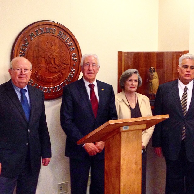 several business people standing around a microphone