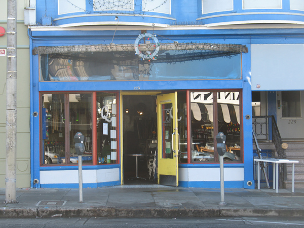 a blue store front with large windows and the window has bright yellow doors