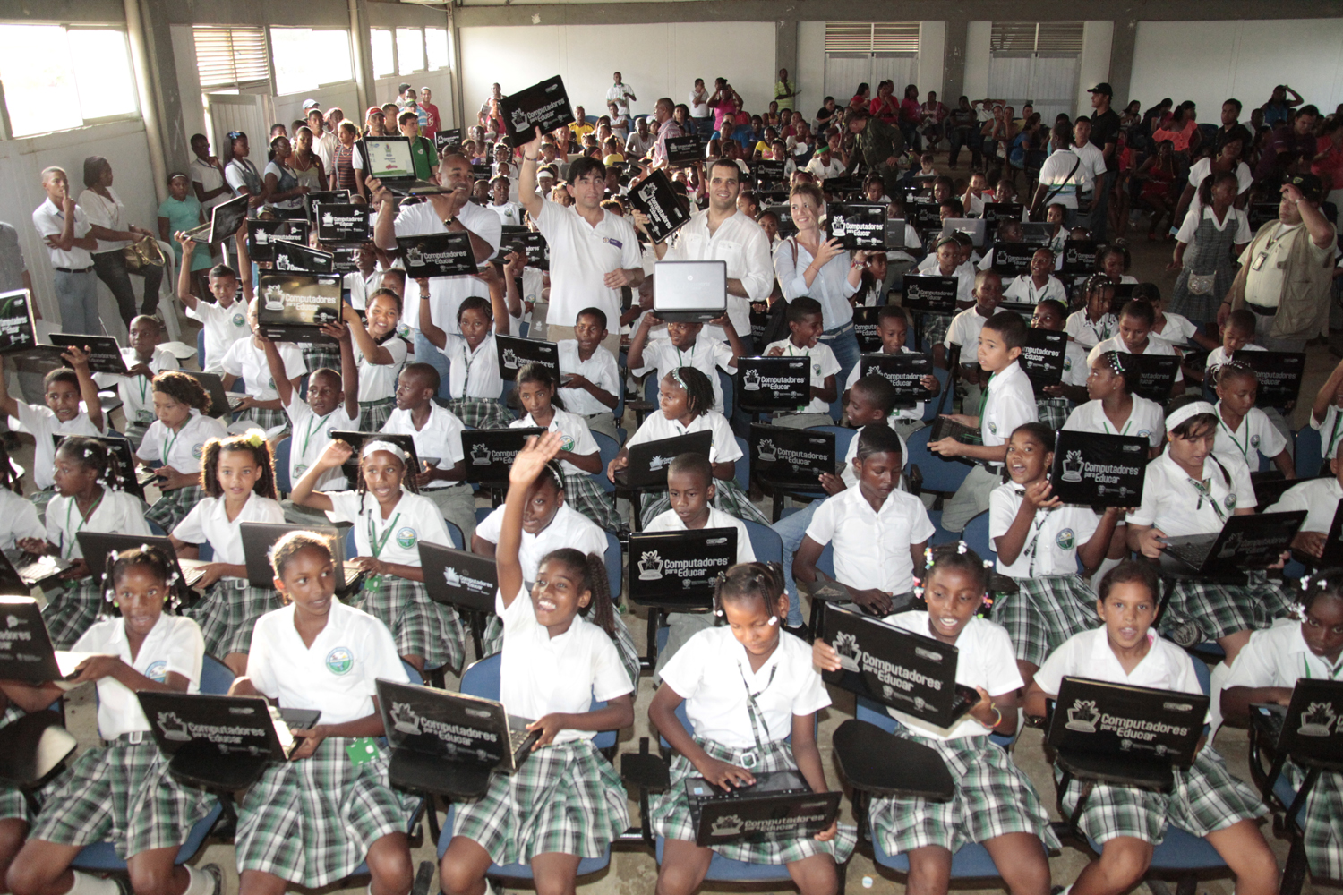 large group of students sitting and standing in school uniforms with black and white signs